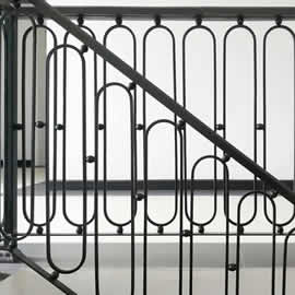 Black iron railing pattern of staircase and corridor on white wall interior design background, black and white, monochrome tone
